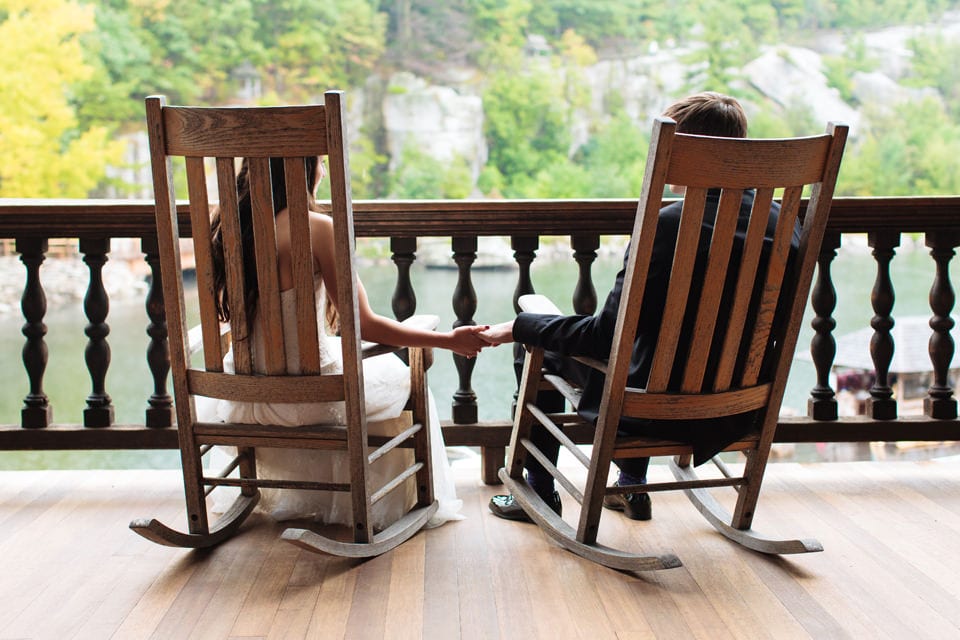Couple holding hands on rocking chairs at Mohonk Mountain House wedding