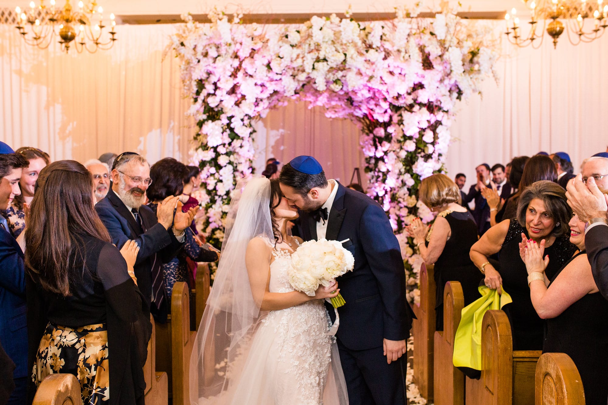 Jewish bride and groom kiss after marriage ceremony in Great Neck, NY.