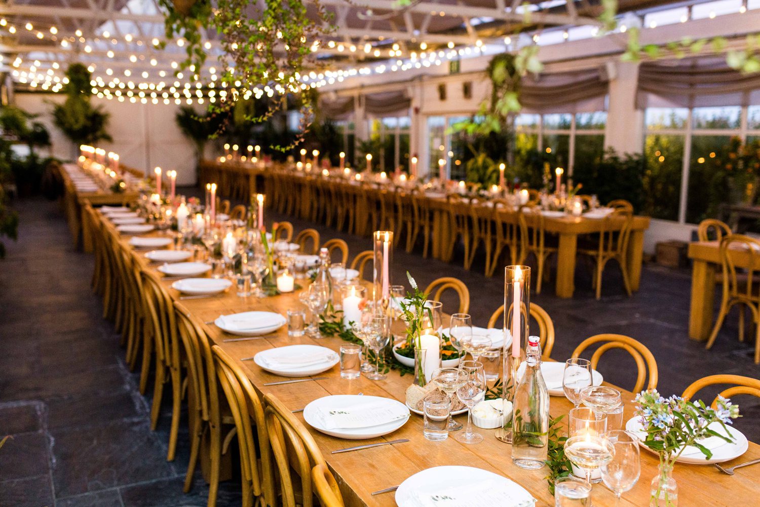Wedding reception table decor at Audrey's Farmhouse Greenhouse featuring candles and floral arrangements in small glass vases