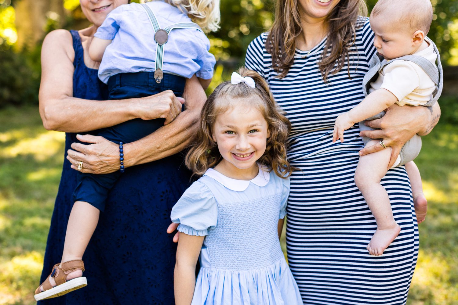 Photo of girl smiling standing between mom and grandma during family photo session